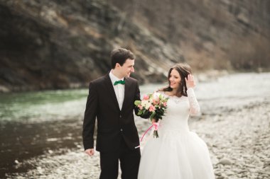 Mutlu evlilik çift, gelin ve damat zemin Dağları nın karşı temiz nehir poz