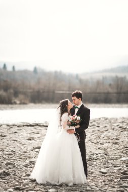 Mutlu evlilik çift, gelin ve damat zemin Dağları nın karşı temiz nehir poz