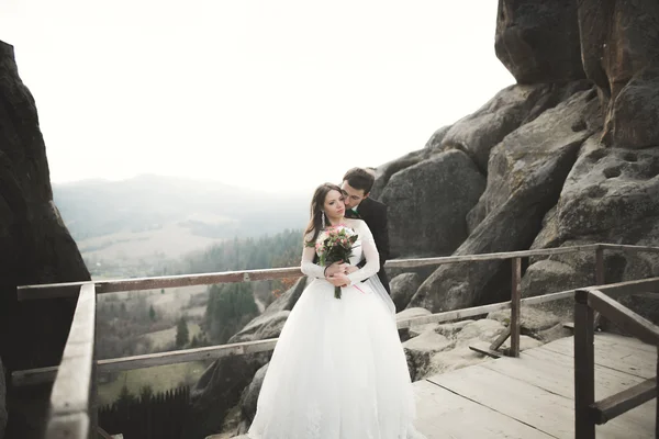 Pareja feliz boda, novia y novio posando cerca de rocas con hermosas vistas —  Fotos de Stock