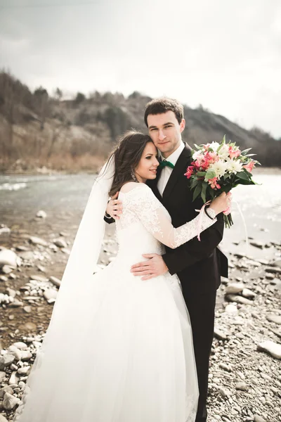 행복 한 웨딩 커플, 신부와 신랑 깔끔한 강 산의 배경으로 포즈 — 스톡 사진