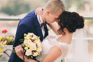 Mutlu düğün çift, Gelin, damat eski şehir manzarası ile öpüşme