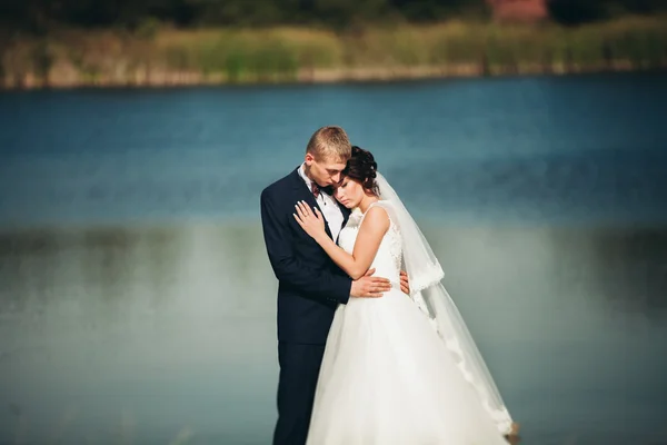 Liefde en passie - kus van getrouwde jonge bruidspaar in de buurt van lake — Stockfoto
