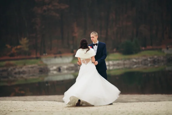 El amor y la pasión - el beso de la pareja casada joven de boda cerca del lago — Foto de Stock