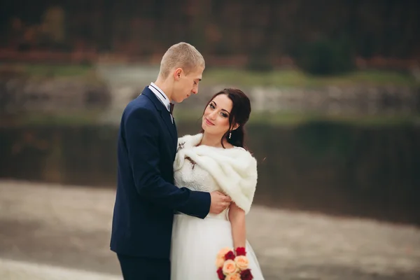 Amor e paixão - beijo do par de casamento jovem casado perto do lago — Fotografia de Stock