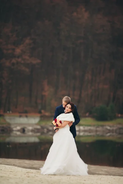 Любовь и страсть - поцелуй молодоженов у озера — стоковое фото