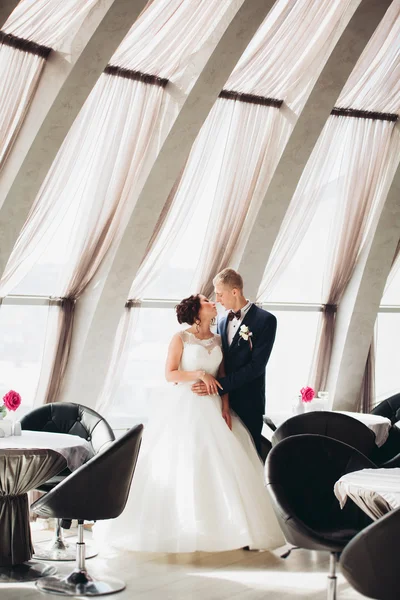 Verheugd huwelijksfeest paar, bruid en bruidegom poseren in hotel — Stockfoto