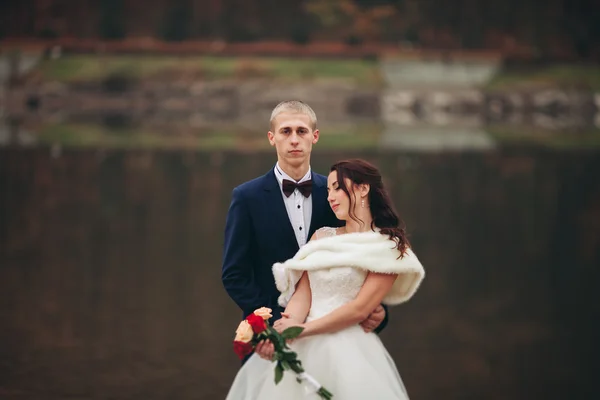 사랑과 열정-호수 근처 결혼된 젊은 웨딩 커플의 키스 — 스톡 사진