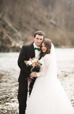 Mutlu evlilik çift, gelin ve damat zemin Dağları nın karşı temiz nehir poz