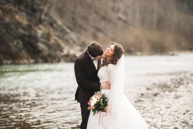 Mutlu evlilik çift, gelin ve damat zemin Dağları nın karşı temiz nehir poz