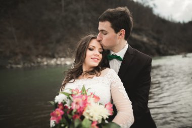 Mutlu evlilik çift, gelin ve damat zemin Dağları nın karşı temiz nehir poz