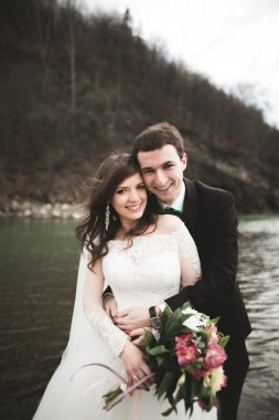 Mutlu evlilik çift, gelin ve damat zemin Dağları nın karşı temiz nehir poz