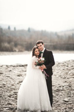 Mutlu evlilik çift, gelin ve damat zemin Dağları nın karşı temiz nehir poz