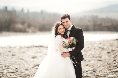 Mutlu evlilik çift, gelin ve damat zemin Dağları nın karşı temiz nehir poz