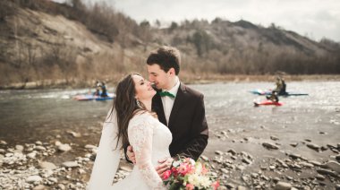 Mutlu evlilik çift, gelin ve damat zemin Dağları nın karşı temiz nehir poz