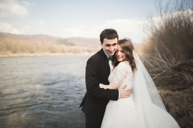 Mutlu yeni evliler, gelin ve damat nehir manzarası ile poz