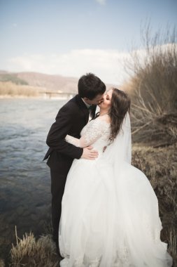 Mutlu yeni evliler, gelin ve damat nehir manzarası ile poz