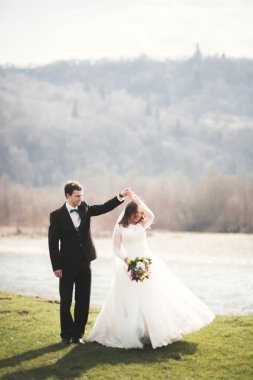 Güzel düğün çift, Gelin, poz ve yüksek Dağları arka planı alanında yürüme damat