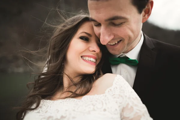 Couple de mariage heureux, mariée et marié posant rivière soignée sur fond de montagnes — Photo