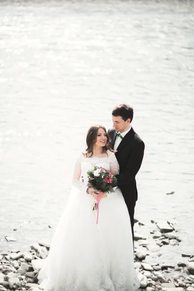 Feliz recién casados, novia y novio posando en el río con hermosas vistas —  Fotos de Stock