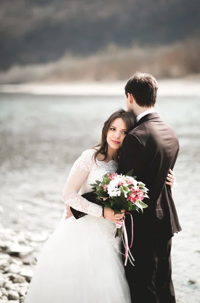 행복 한 신혼, 신부 및 신랑 아름 다운 전망 가진 강에 포즈 — 스톡 사진