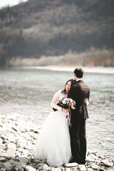 Feliz recién casados, novia y novio posando en el río con hermosas vistas —  Fotos de Stock