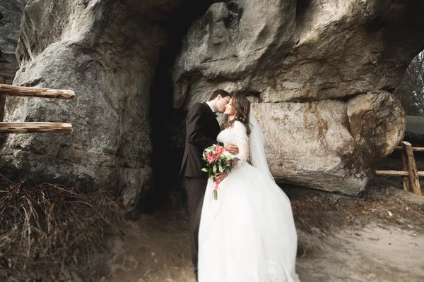 Casal feliz beijando e abraçando perto de um penhasco alto — Fotografia de Stock