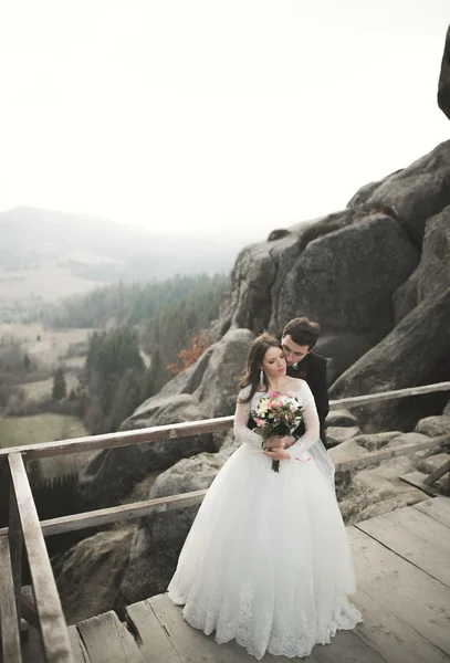 Casamento casal no amor beijando e abraçando perto de pedras na bela paisagem — Fotografia de Stock