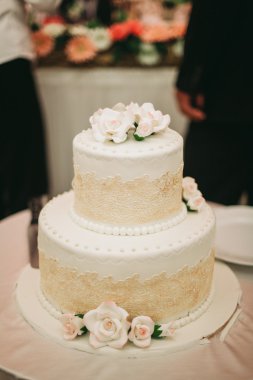 Masada süslü düğün pastası var.