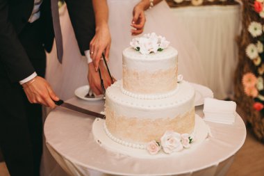 Masada süslü düğün pastası var.