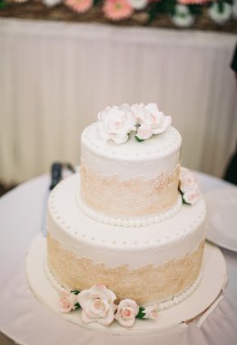 Masada süslü düğün pastası var.