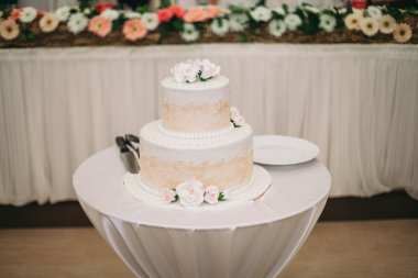 Masada süslü düğün pastası var.