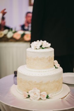 Masada süslü düğün pastası var.