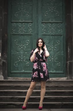 Güzel esmer genç kadın eski şehirde sokakta poz