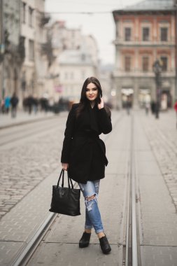 Güzel esmer genç kadın eski şehirde sokakta poz