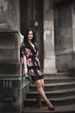 Güzel esmer genç kadın eski şehirde sokakta poz