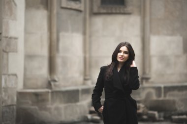 Güzel esmer genç kadın eski şehirde sokakta poz