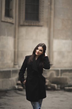 Güzel esmer genç kadın eski şehirde sokakta poz