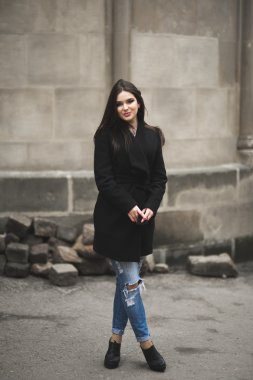 Güzel esmer genç kadın eski şehirde sokakta poz