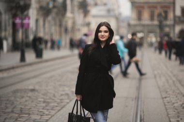 Güzel esmer genç kadın eski şehirde sokakta poz