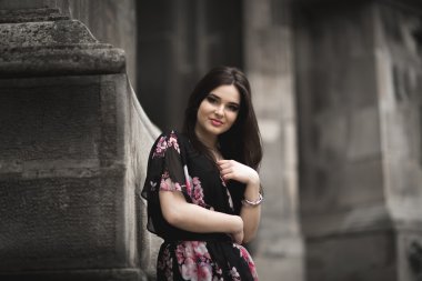 Güzel esmer genç kadın eski şehirde sokakta poz