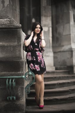 Güzel esmer genç kadın eski şehirde sokakta poz