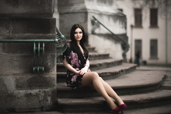 Krásná brunetka mladá žena pózuje na ulici ve starém městě — Stock fotografie