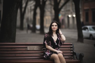 Güzel esmer genç kadın eski şehirde sokakta poz