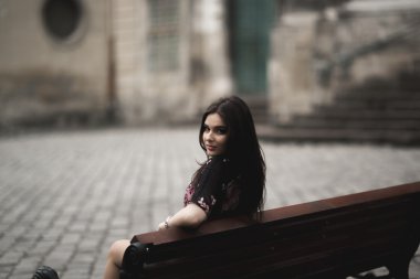 Güzel esmer genç kadın eski şehirde sokakta poz