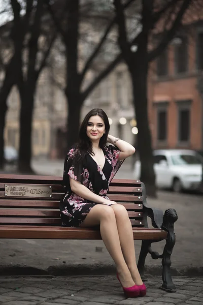 Mooie brunette jonge vrouw die zich voordeed op de straat in de oude stad — Stockfoto