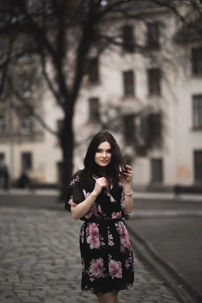 Mooie brunette jonge vrouw die zich voordeed op de straat in de oude stad — Stockfoto