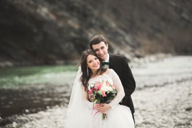 Mutlu evlilik çift, gelin ve damat zemin Dağları nın karşı temiz nehir poz