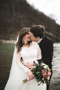 Mutlu evlilik çift, gelin ve damat zemin Dağları nın karşı temiz nehir poz