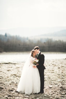 Mutlu evlilik çift, gelin ve damat zemin Dağları nın karşı temiz nehir poz