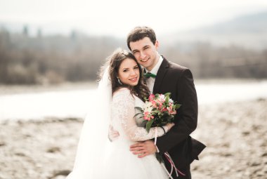 Mutlu evlilik çift, gelin ve damat zemin Dağları nın karşı temiz nehir poz